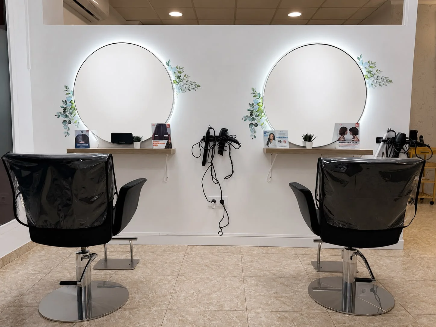 Zona de peluquería de Dayanna Beauty Studio en Puerto de Mazarrón: dos sillones frente a espejos redondos retroiluminados